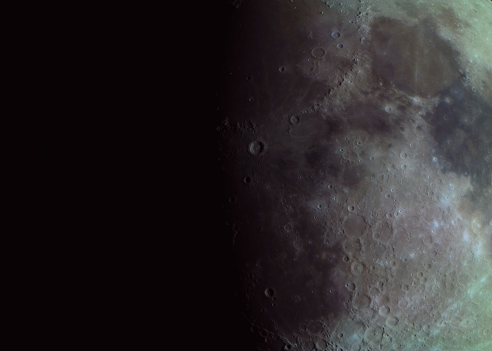 Superfície da Lua vista de perto, cheia de crateras, com metade iluminada e metade na sombra contra o céu escuro